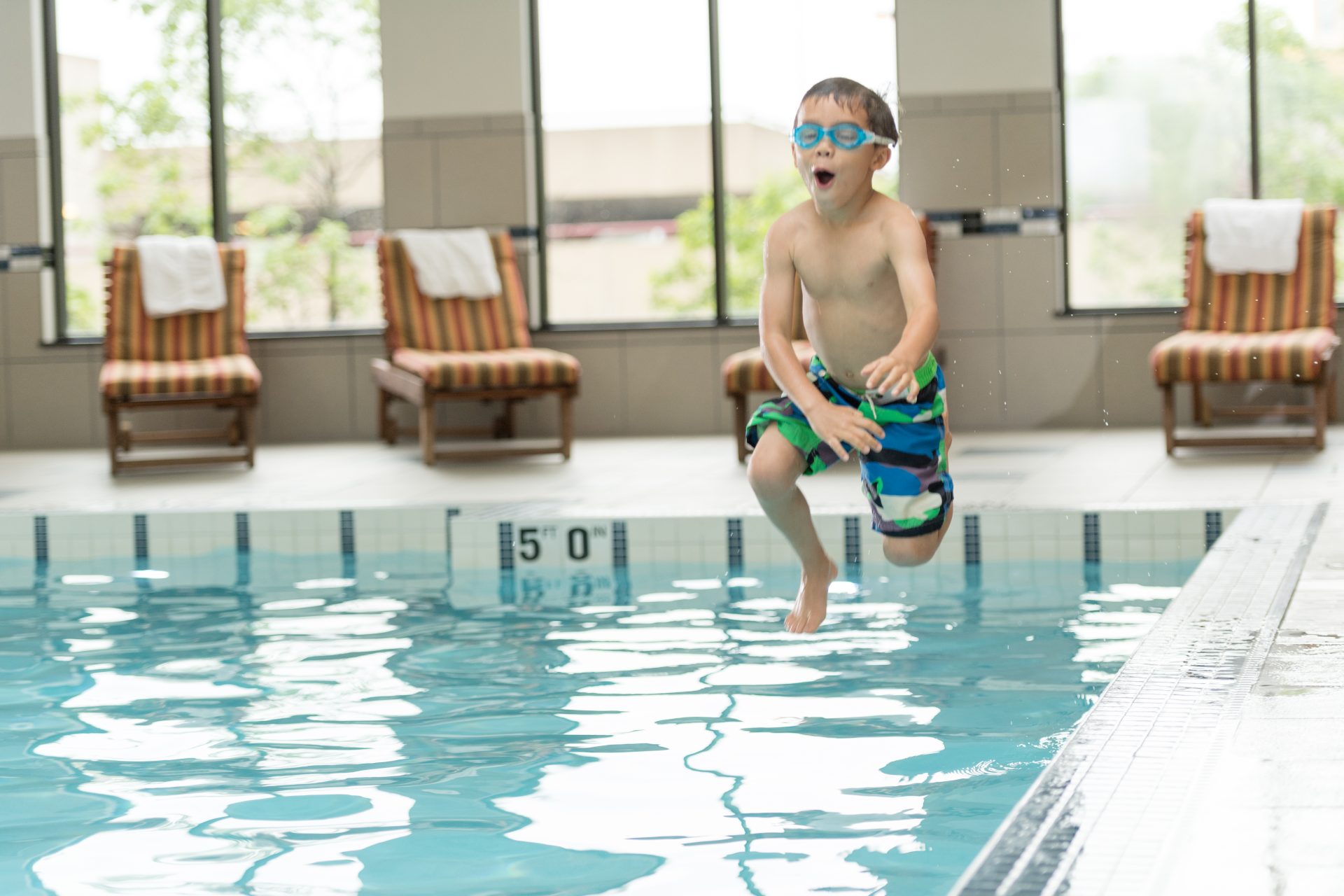 Boy jumping into pool
