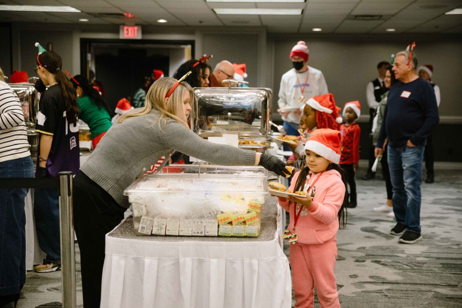 Employee serving food at holiday party for area children